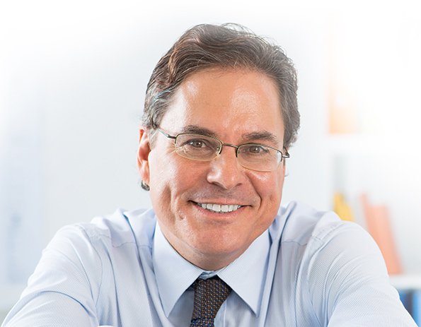 Brown-haired male insurance worker wearing glasses and smiling