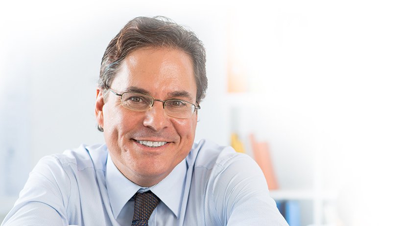 Brown-haired male insurance worker wearing glasses and smiling